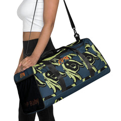 Woman carrying blue and green patterned OPM duffle bag with shoulder strap