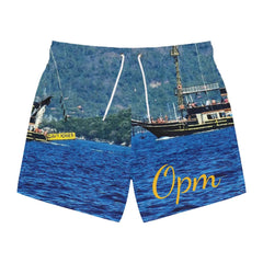 Men's swim trunks with ocean and boat print, yellow 'Opm' script on blue background