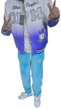 Person wearing a gradient jacket with text and graphics, blue pants, and white shoes on a transparent background.
