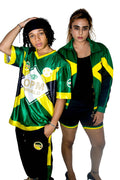 Two people wearing green and yellow sports outfits with visible branding on a white background