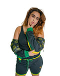 Woman wearing a green and black outfit with yellow accents against a white background