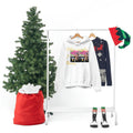White unisex hoodie with graphic and 'Other peoples Money' text on clothing rack, next to a Christmas tree, festive sweater, elf hat, and striped boots.