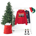 Red graphic unisex hoodie and Christmas sweater on rack with festive holiday decor