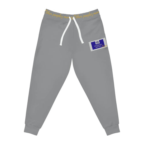 Grey joggers with white drawstring, yellow waistband text, blue patch on left leg