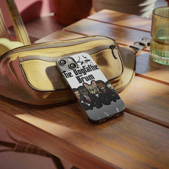 Dogfather Brum phone case with illustrated dogs in suits on a wooden table beside a beige bag.