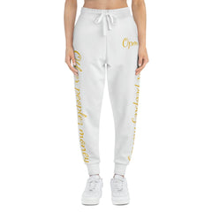 White joggers with gold script text, drawstring waist, worn by a model