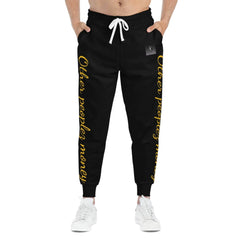 Black joggers with yellow 'Other peoples money' script on legs, drawstring waist, streetwear style