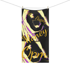 Black and yellow cotton towel with abstract print and gold script text 'Other Peoples Money Opm' hanging on a line.