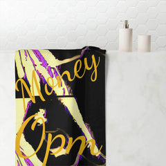Black and yellow cotton towel with gold 'Money Opm' text, draped on a white surface