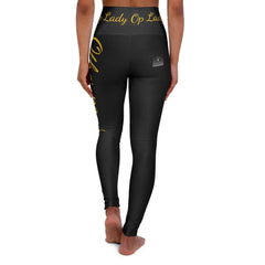 Woman wearing black high-waisted leggings with gold lettering, rear view