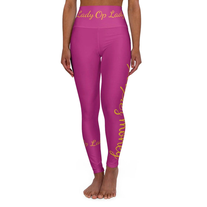 Pink high-waisted yoga leggings with yellow script text, modeled on a white background