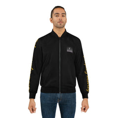 Man wearing black bomber jacket with gold writing on sleeves and logo patch on chest