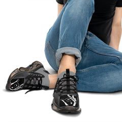 Black mesh sneakers with white graphic hand design, worn with rolled blue jeans