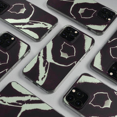Patterned black and white phone cases with abstract design, displayed flat on a grey surface
