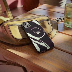 Abstract black and white phone case on a brown bag, stylish streetwear accessory