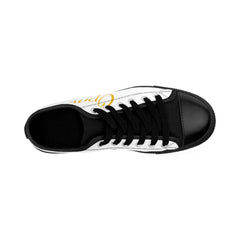 Top view of white and black low-top sneaker with gold script detail, streetwear style.