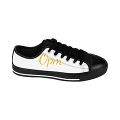 White and black low-top sneaker with gold 'Opm' text, black laces and sole