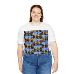 Smiling woman wearing white short sleeve tee with colorful graphic text, paired with jeans