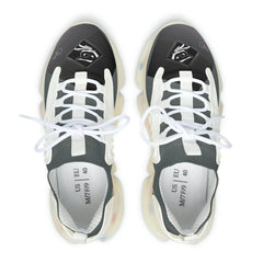 Black and white mesh women's sneakers with eye graphics and chunky translucent soles, top view.